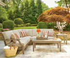Beige outdoor sectional sofa with striped throw pillows and patterned accent cushions