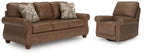 Dark brown sofa with two patterned accent pillows and matching recliner chair