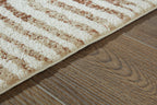 Area rug detail: cream pile with rust patterned bands along the edge