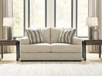 Beige loveseat with two seat cushions and three back pillows with striped patterns