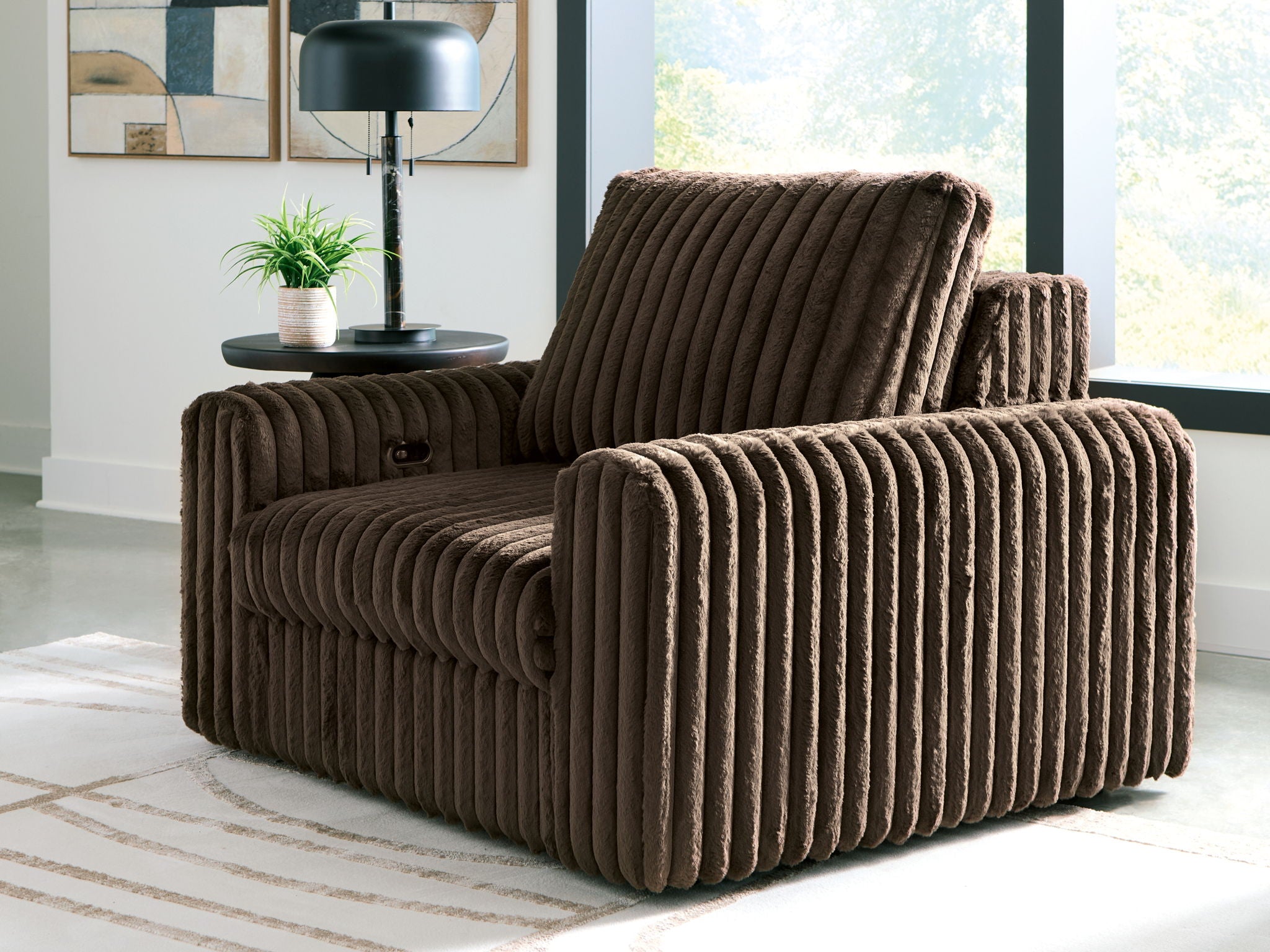 Chocolate corduroy power gliding chaise with curved arms and tall backrest.