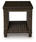 Rectangular woven patio table with dark brown tabletop and open storage shelf