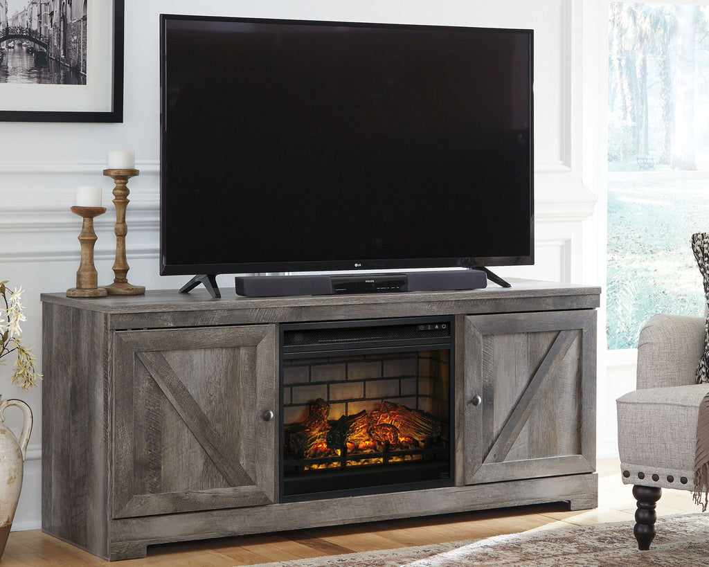 Gray media console with TV on top and glowing fireplace insert in center cabinet