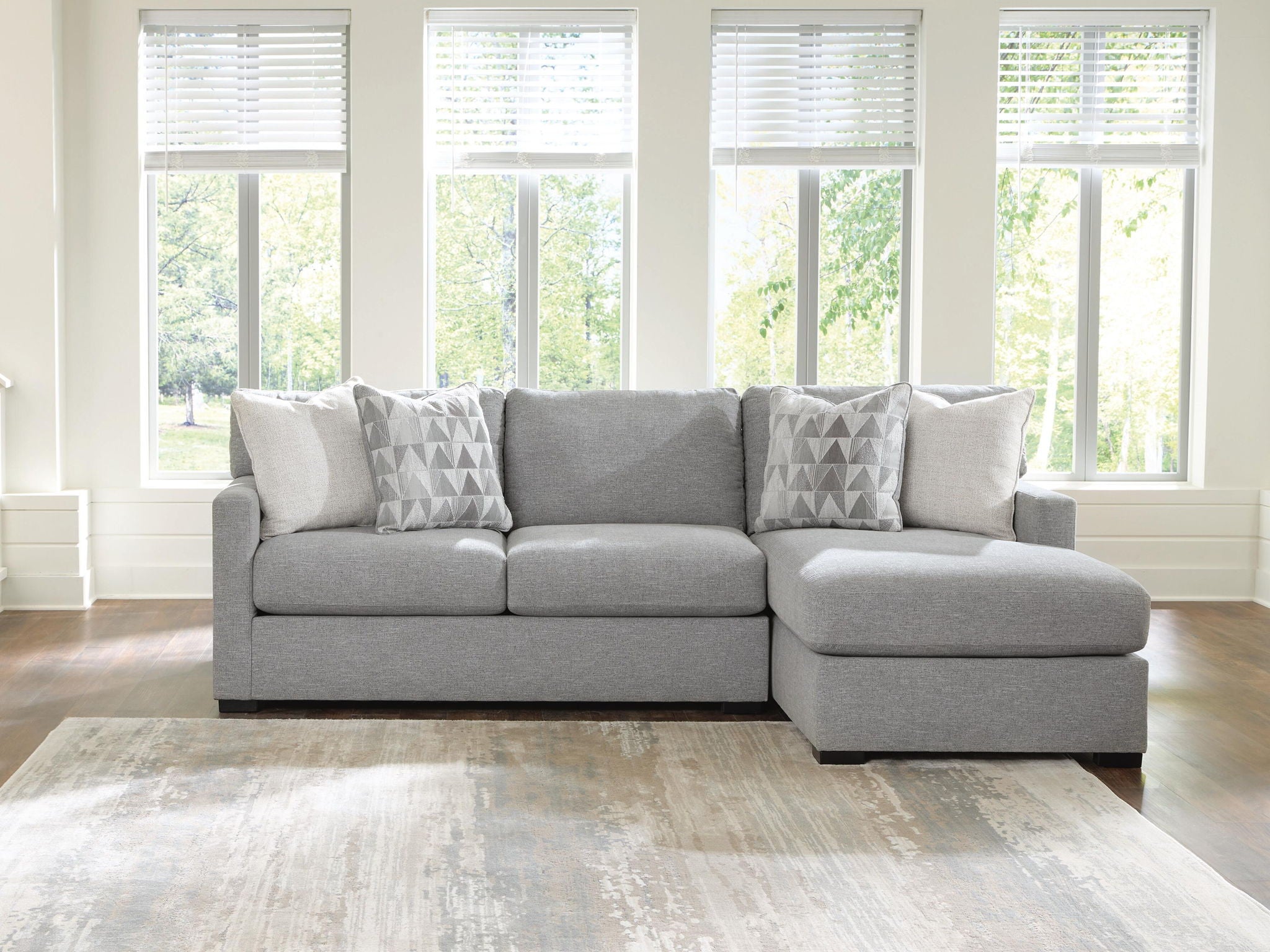 Dark gray sleeper sectional sofa with chaise seat and three geometric accent pillows