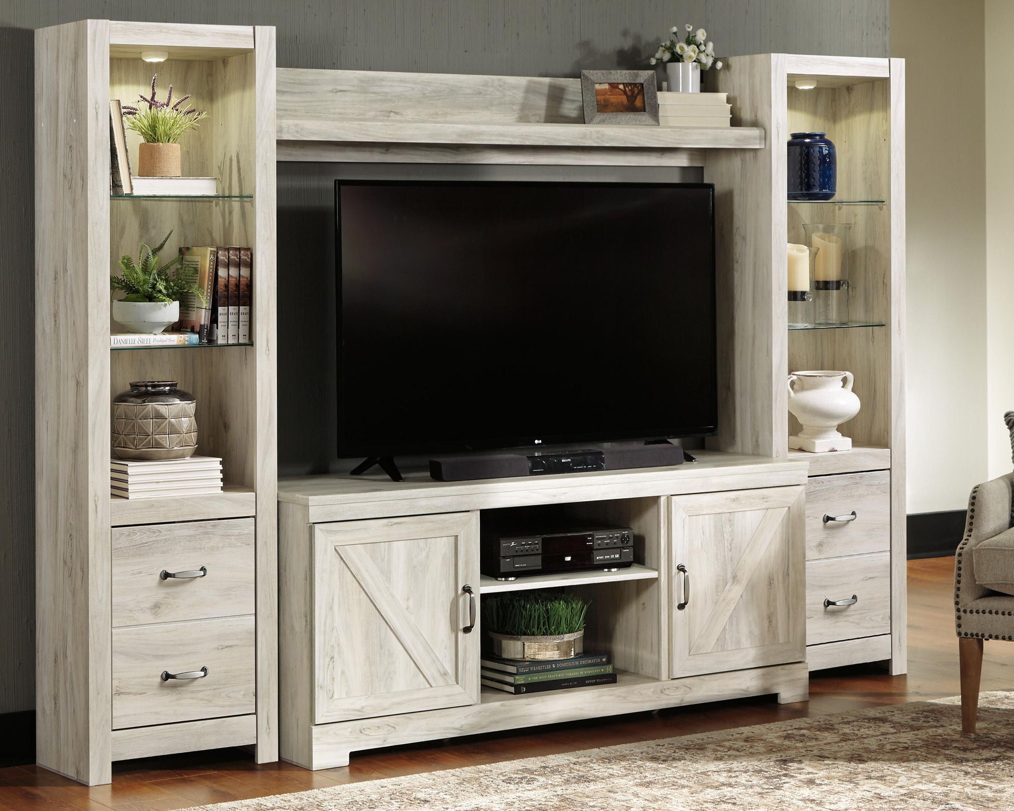 Beige TV entertainment center with open shelves, media cabinet, and drawers.