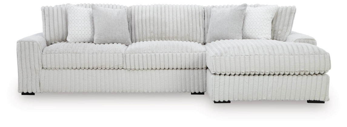 Sectional sofa with chaise, light-colored striped fabric and multiple back pillows