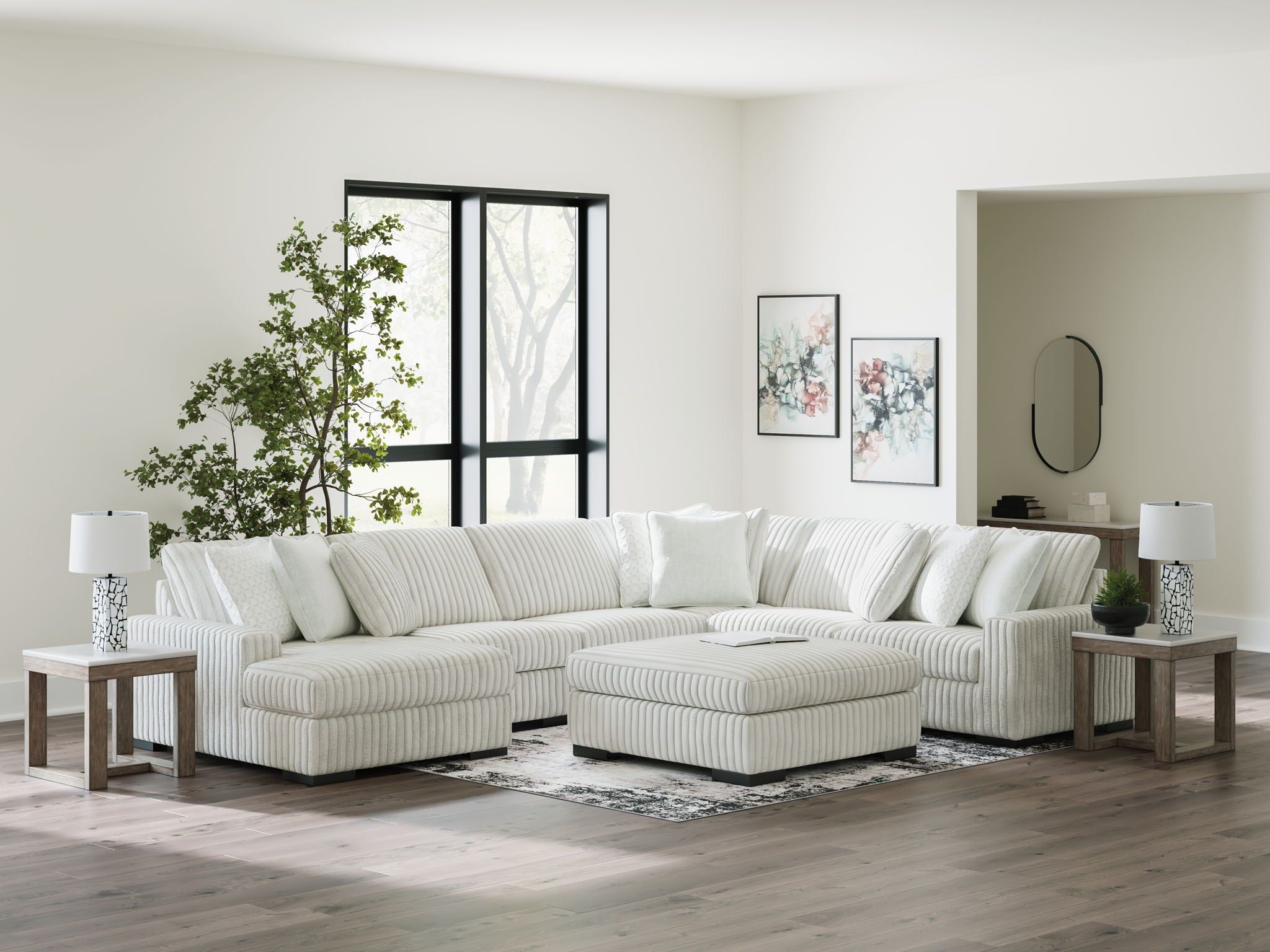 Off-white striped sectional sofa with chaise corner and multiple throw pillows.