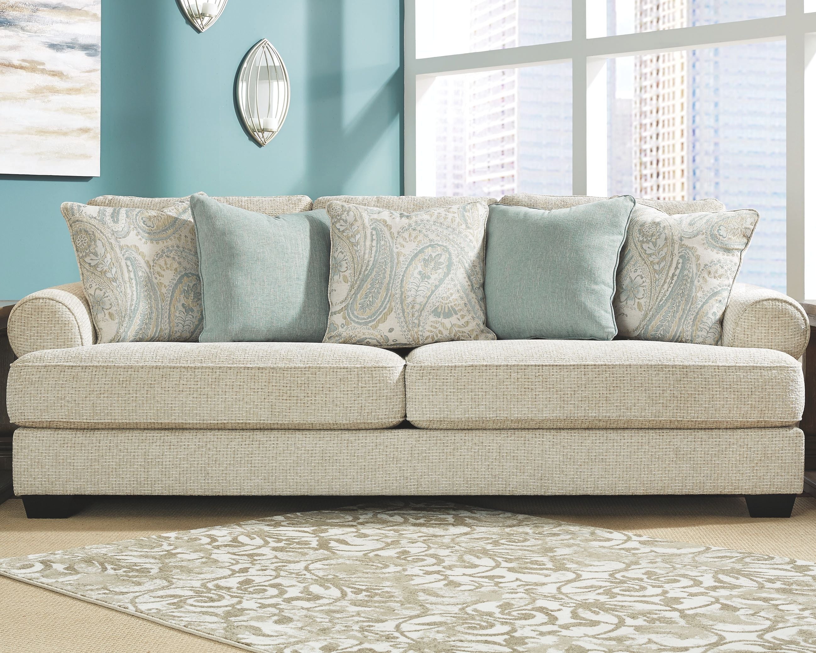Beige fabric sofa with blue and patterned throw pillows, seat cushions and box base