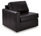 Black upholstered corner chair with wide armrests and tufted back cushion