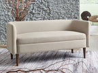 Beige upholstered accent bench with rounded back and seat, dark tapered legs
