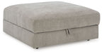 Gray upholstered ottoman with square padded top and short black legs