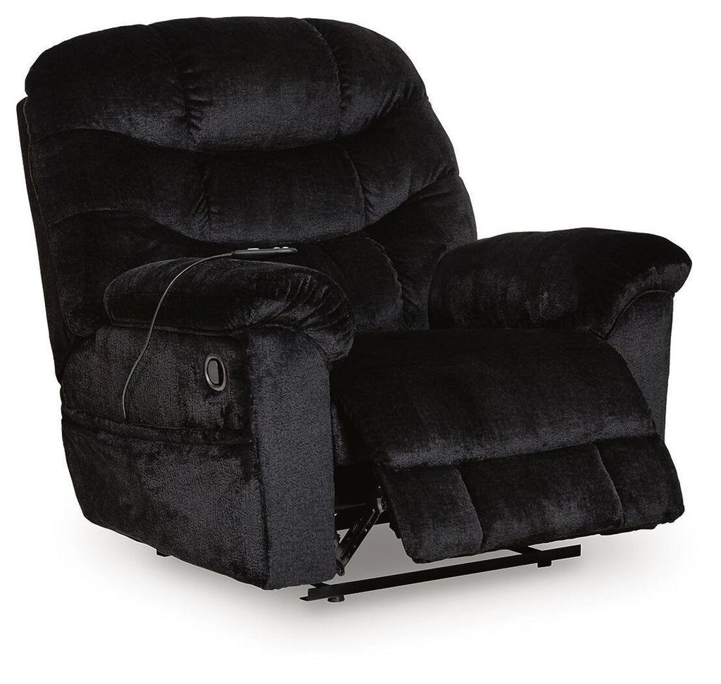 Black upholstered recliner chair with headrest, button-tufted back, padded arms, and base