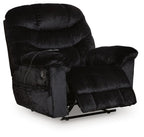 Black upholstered recliner chair with headrest, button-tufted back, padded arms, and base