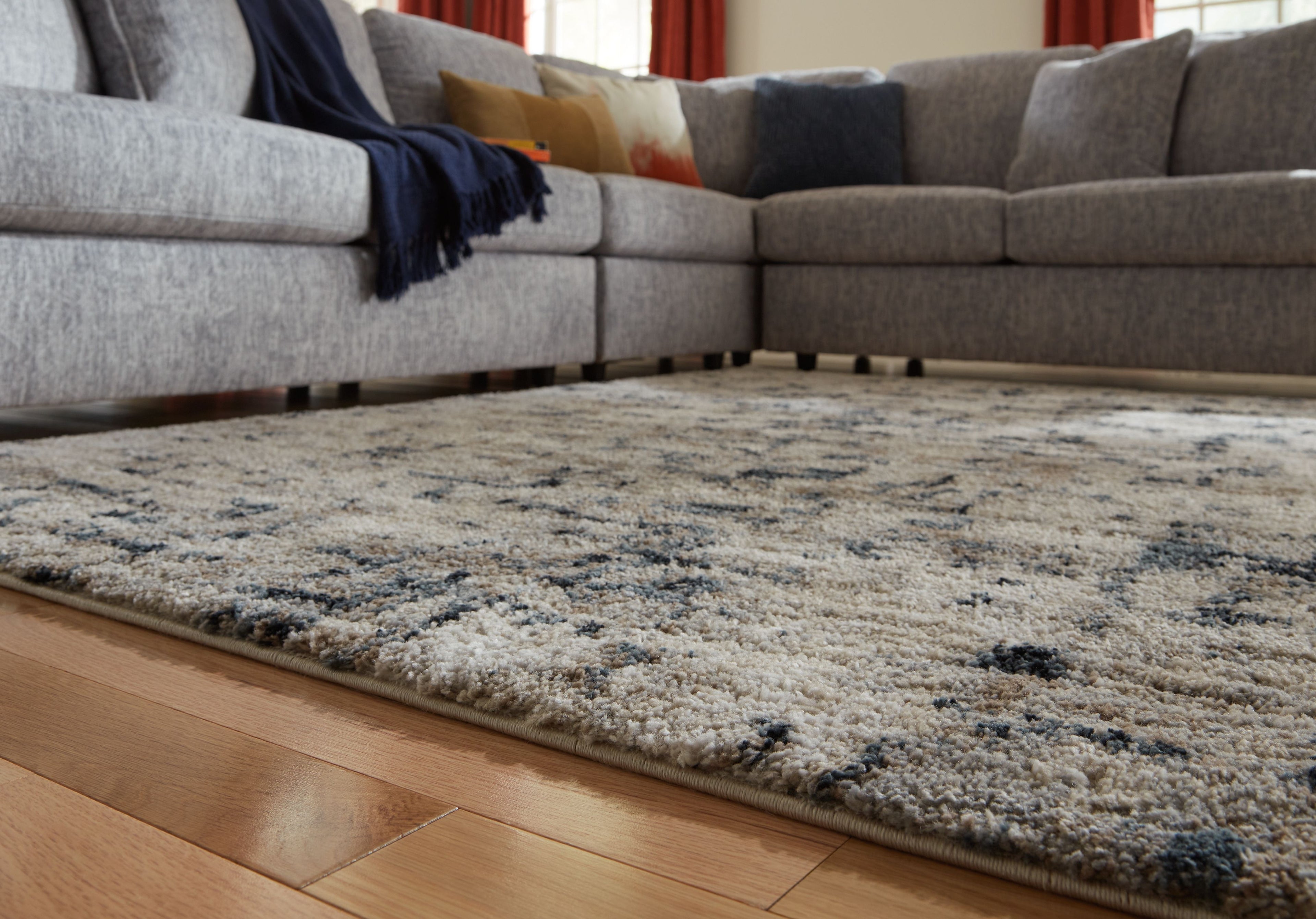 Distressed grey and off-white area rug on hardwood floor; rectangular full view