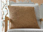 Tan woven decorative pillow on gray chair, square shape with stitched edge