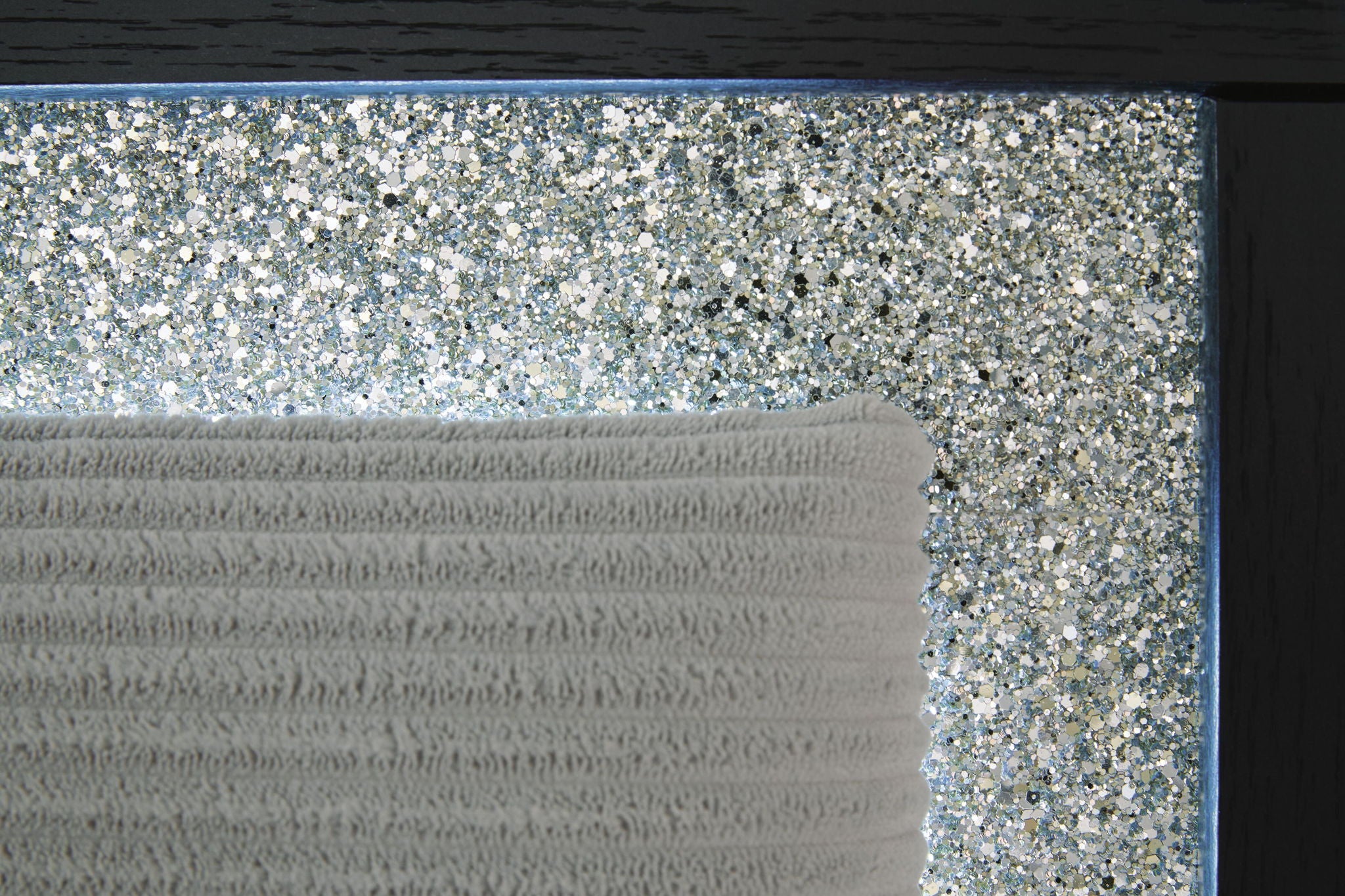 Upholstered headboard with glittery textured panel insert and light gray fabric top.
