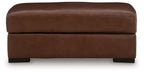 Brown leather rectangular ottoman with rounded top and visible side seams