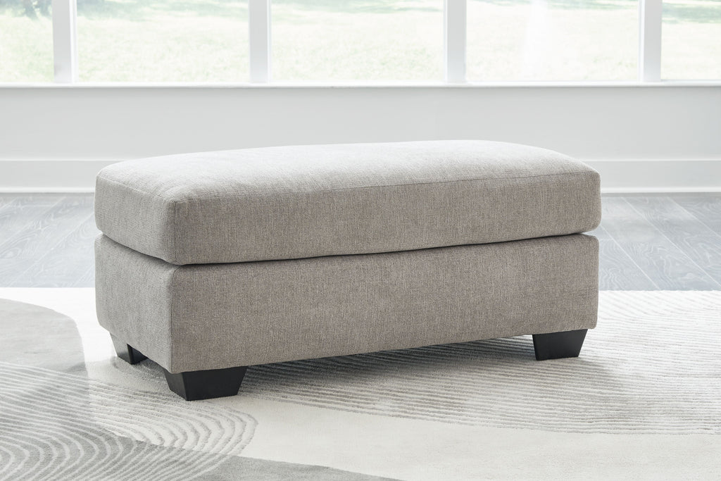 Light gray flannel ottoman with dark legs and rounded seat