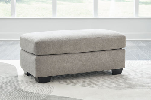 Light gray flannel ottoman with dark legs and rounded seat