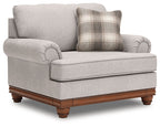 Light-gray chair and a half with plaid cushion, deep seat, and dark wood legs