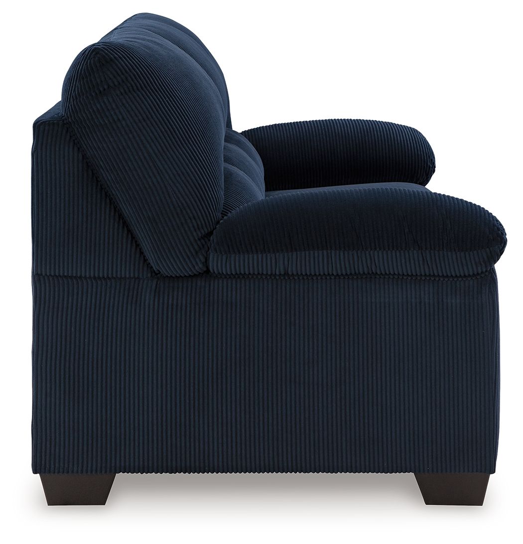 Navy ribbed sofa with rolled arms, thick backrest, and dark legs