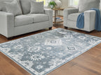 Gray washable rug laid in living room with white floral and border medallion design