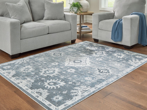 Gray washable rug laid in living room with white floral and border medallion design