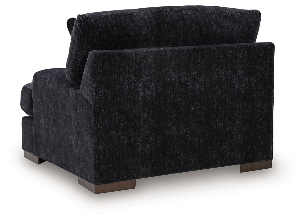 Black upholstered chair-and-a-half with high back, rounded arms, and angled front view