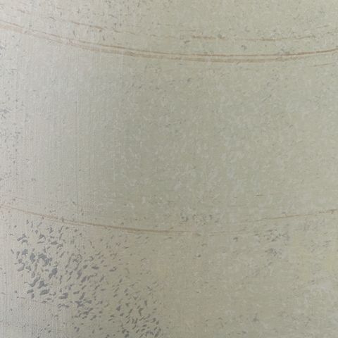 Cream vase close-up with speckled glaze texture and faint horizontal line.