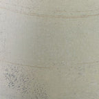 Cream vase close-up with speckled glaze texture and faint horizontal line.