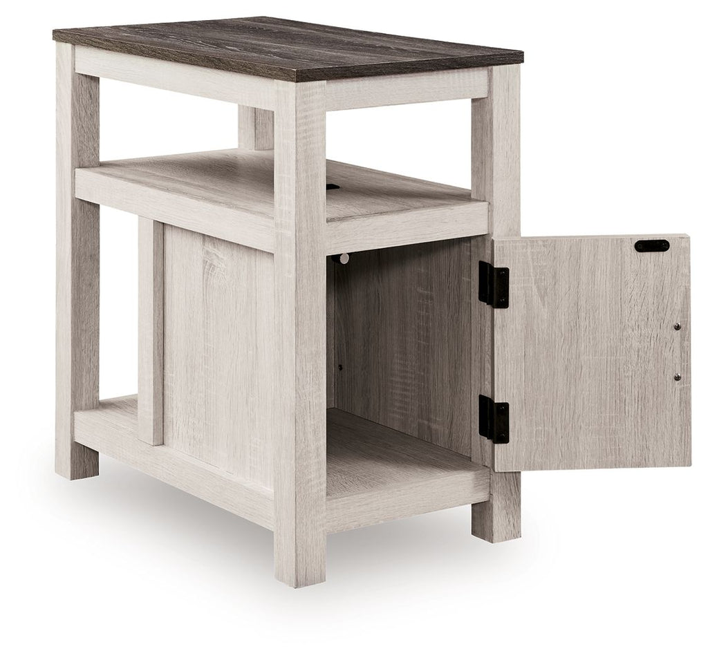 Chair side end table with open shelf and one-door cabinet, light wood finish, two black handles.