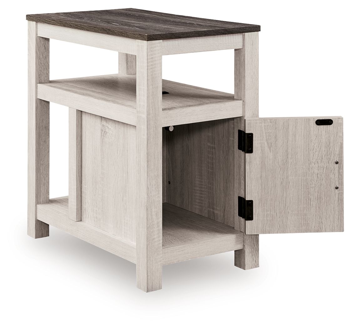 Chair side end table with open shelf and one-door cabinet, light wood finish, two black handles.