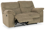 Reclining loveseat in beige fabric with extended footrest and visible mechanism