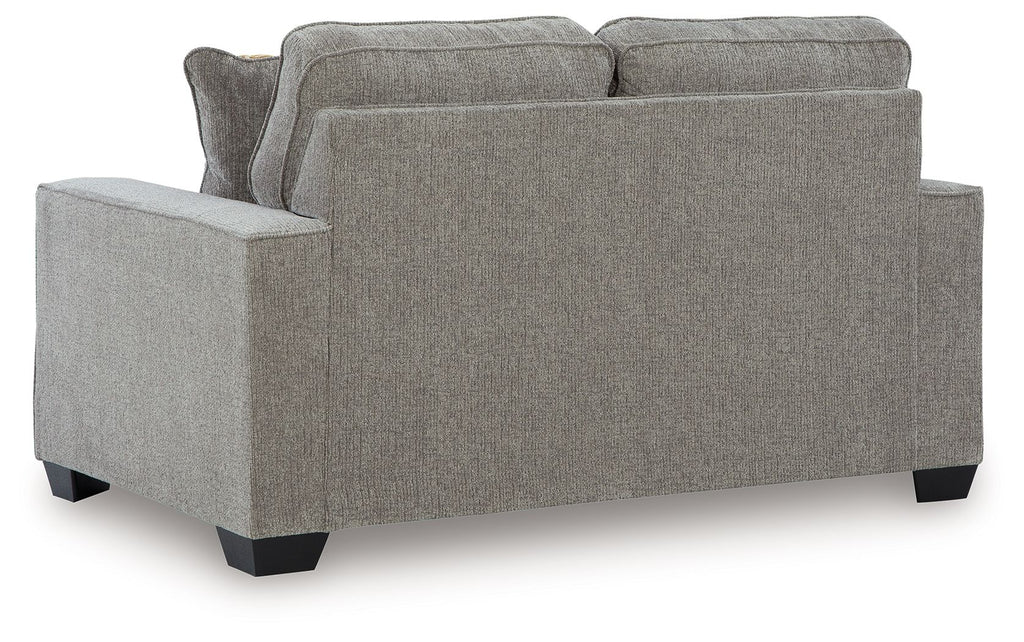 Gray upholstered loveseat with two back cushions and thick armrests