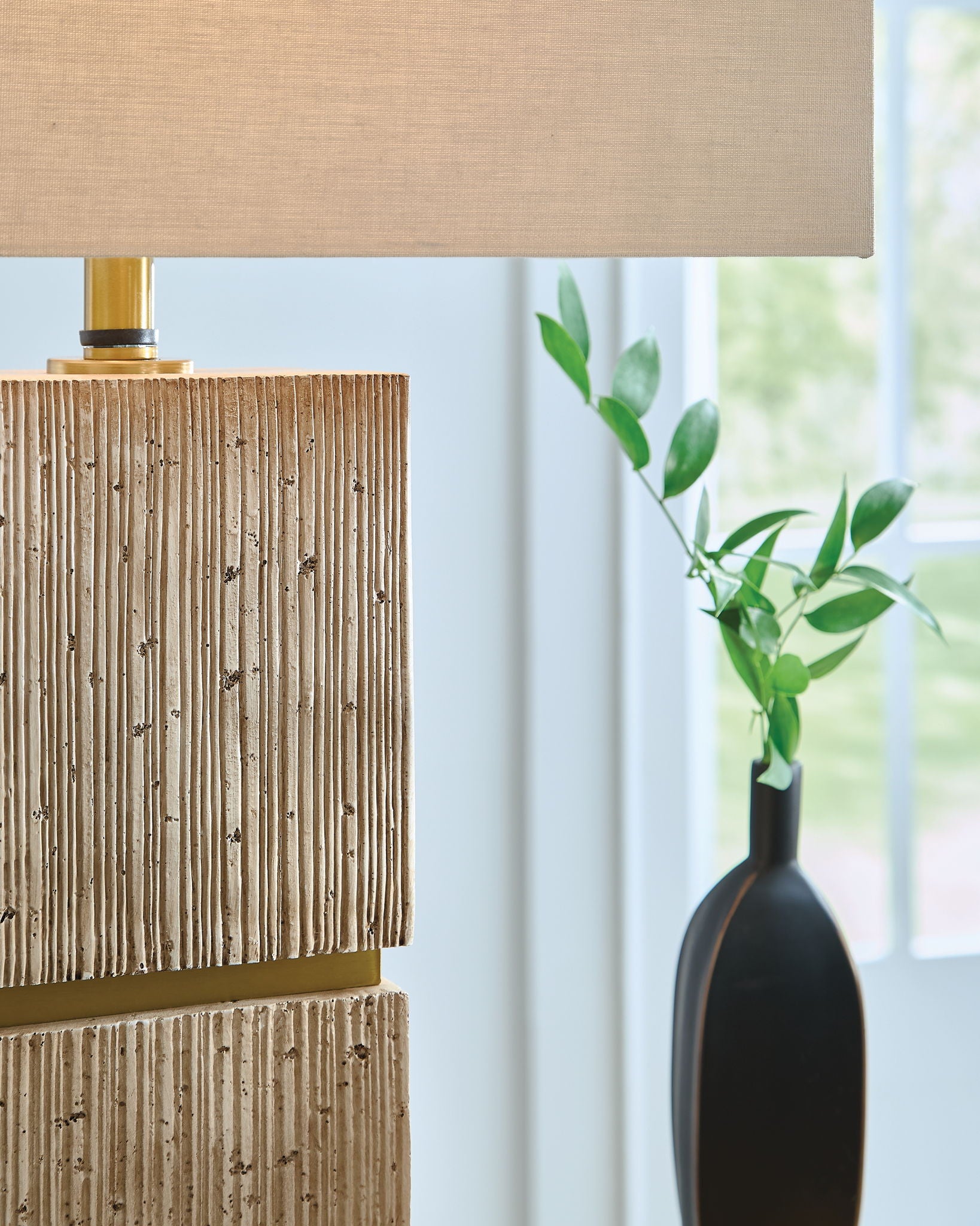 Beige fabric table lamp shade above stacked textured wood blocks