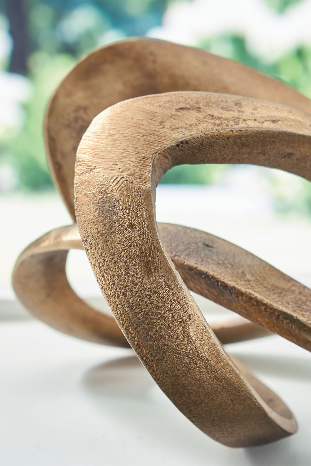 Antique brass metal sculpture close-up of interlocking oval loop shapes