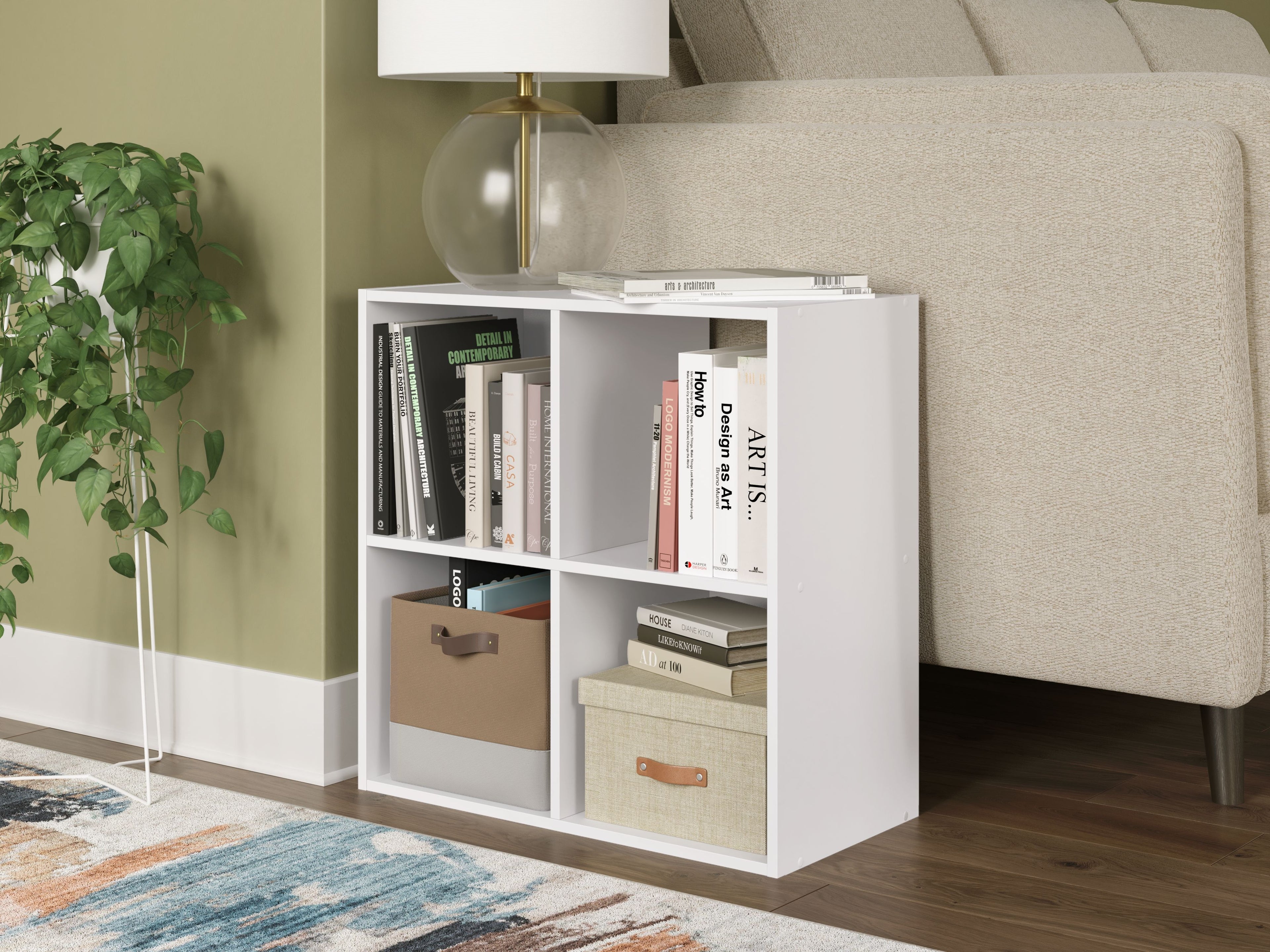 White cube organizer unit with open cubby compartments holding books and storage boxes