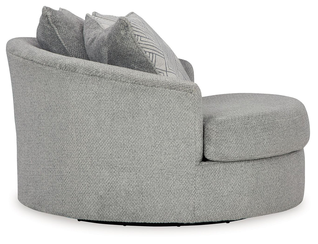 Oversized swivel accent chair in cement gray, view from side with patterned cushions