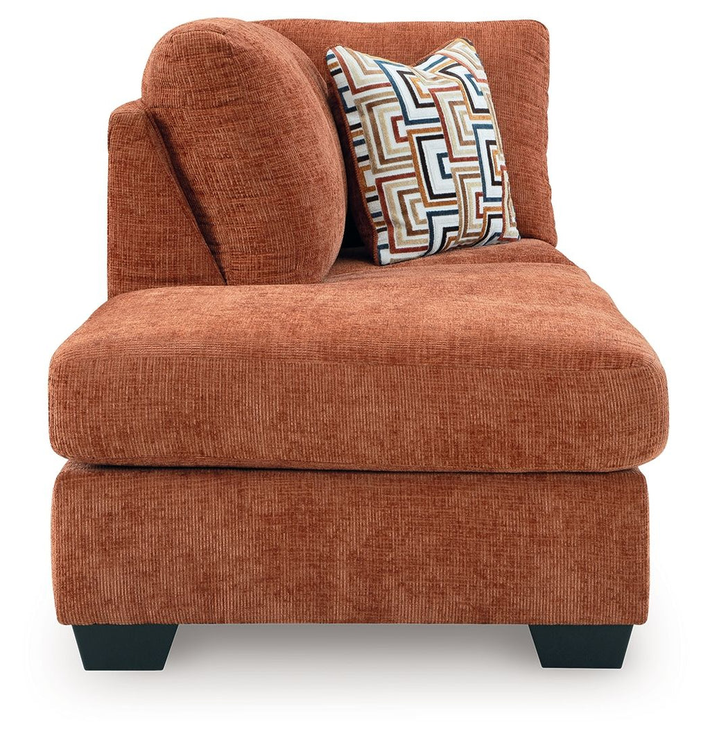 Spice brown upholstered chaise chair with thick seat cushion and patterned throw pillow