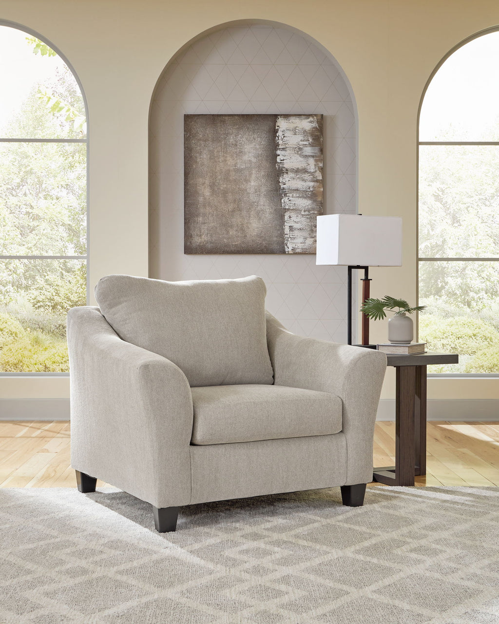 Taupe upholstered chair with rounded arms and dark legs, cushioned seat