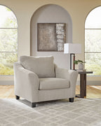 Taupe upholstered chair with rounded arms and dark legs, cushioned seat