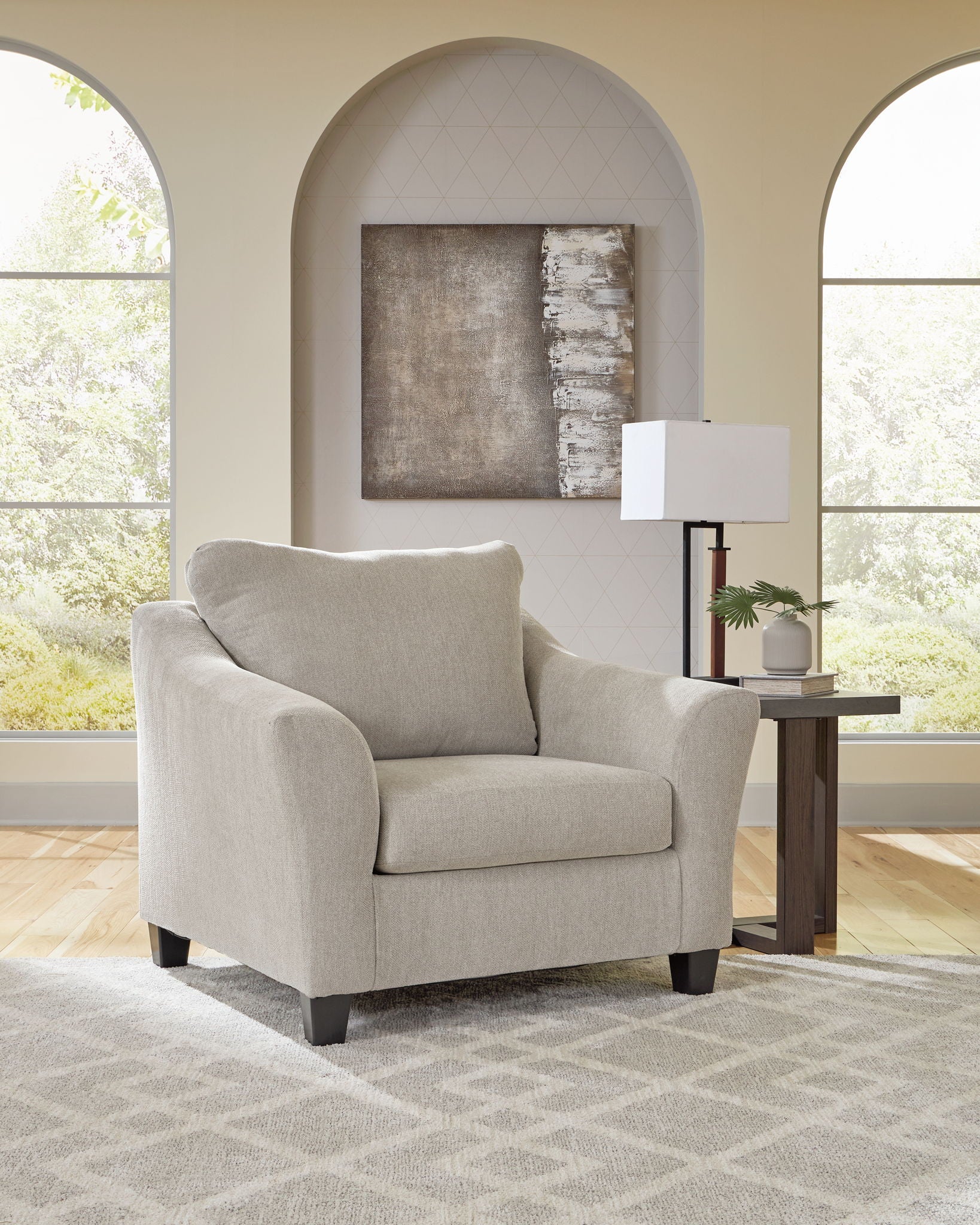 Taupe upholstered chair with rounded arms and dark legs, cushioned seat