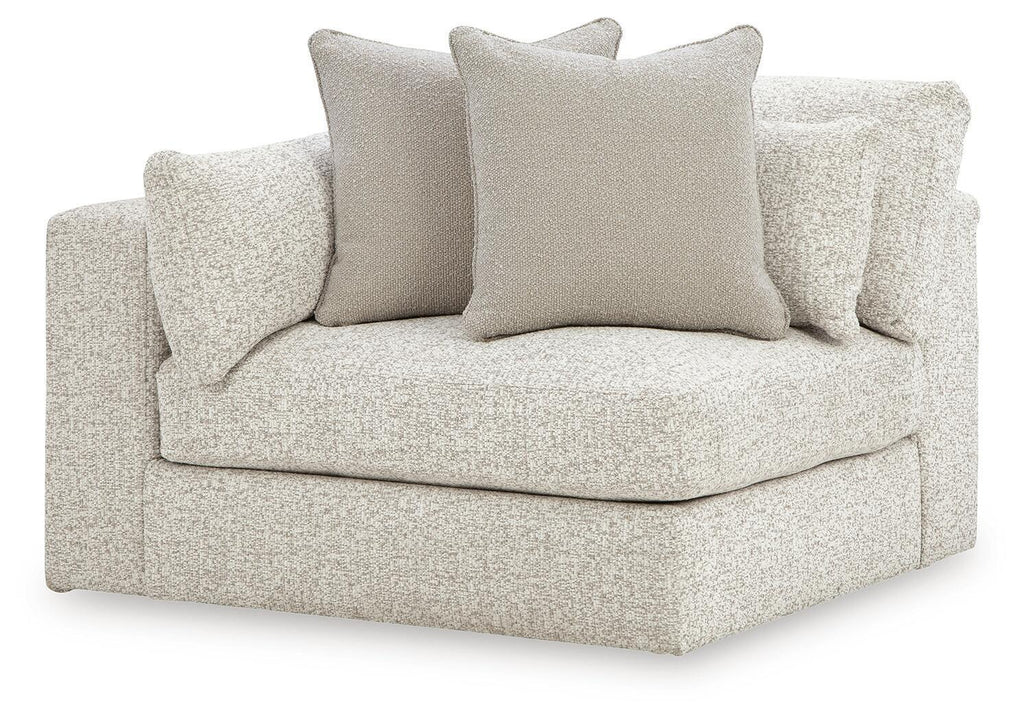 Light textured corner chair with wide seat, short arms, and four square throw cushions