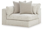 Light textured corner chair with wide seat, short arms, and four square throw cushions