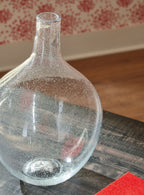 Clear glass vase with speckled specks and narrow neck, shown at a 3/4 angle.