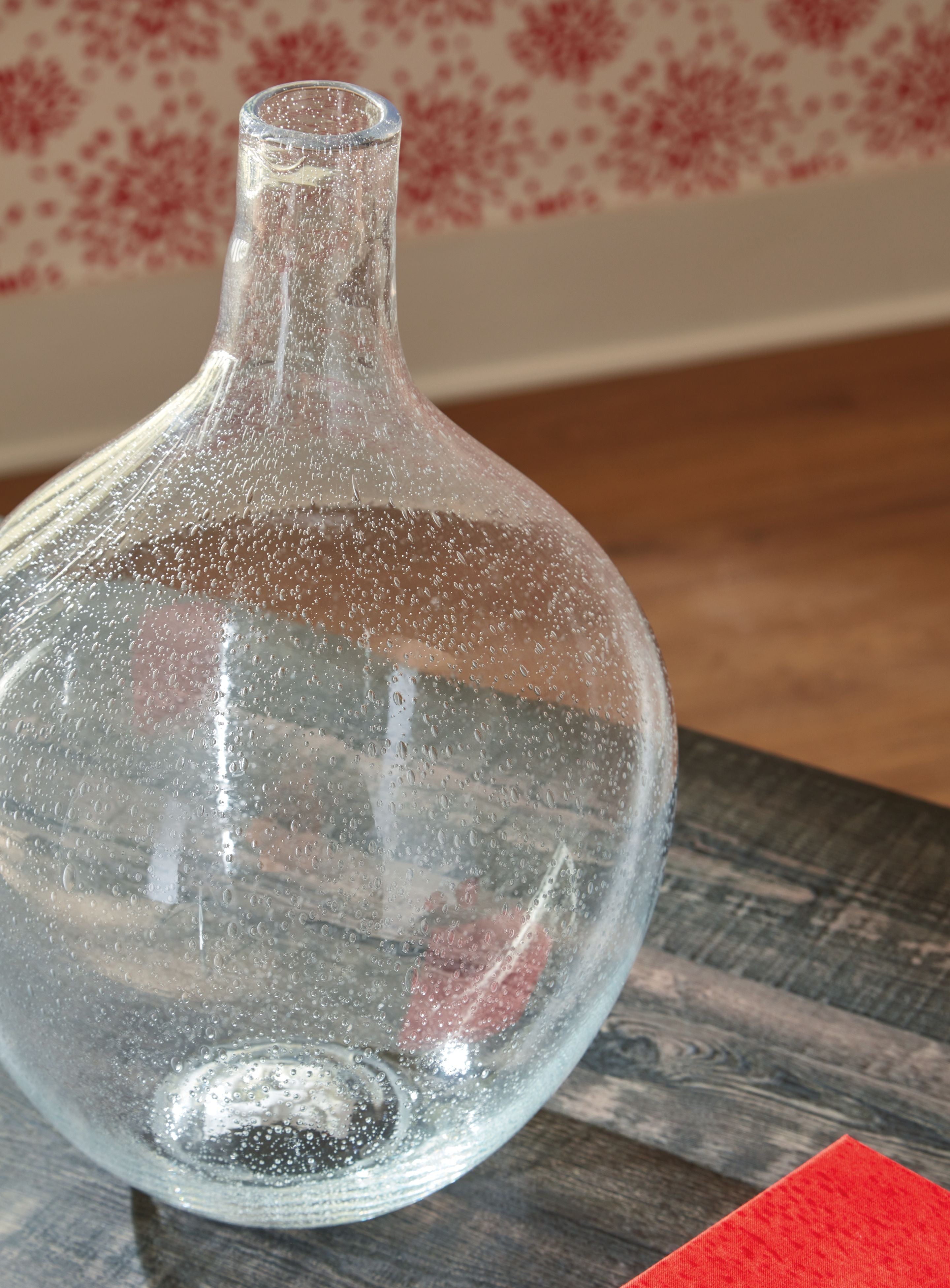 Clear glass vase with speckled specks and narrow neck, shown at a 3/4 angle.