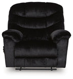 Black upholstered recliner with tufted back cushions, wide arms, and low front base