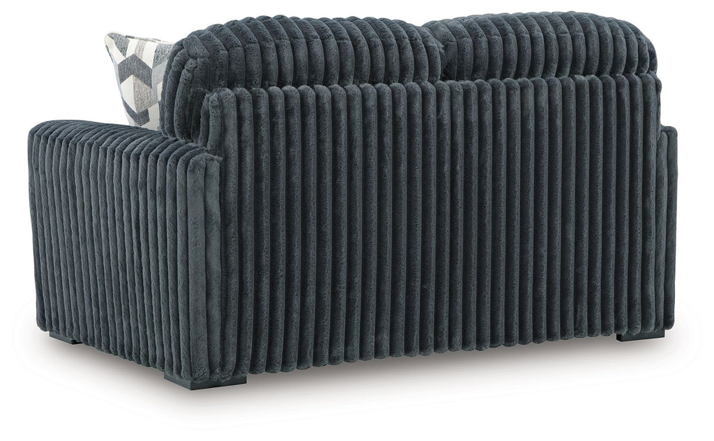 Dark gray corduroy loveseat, side view with ribbed fabric and rounded armrest
