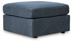 Ink blue fabric ottoman with lift top and low dark legs, rectangular cushion