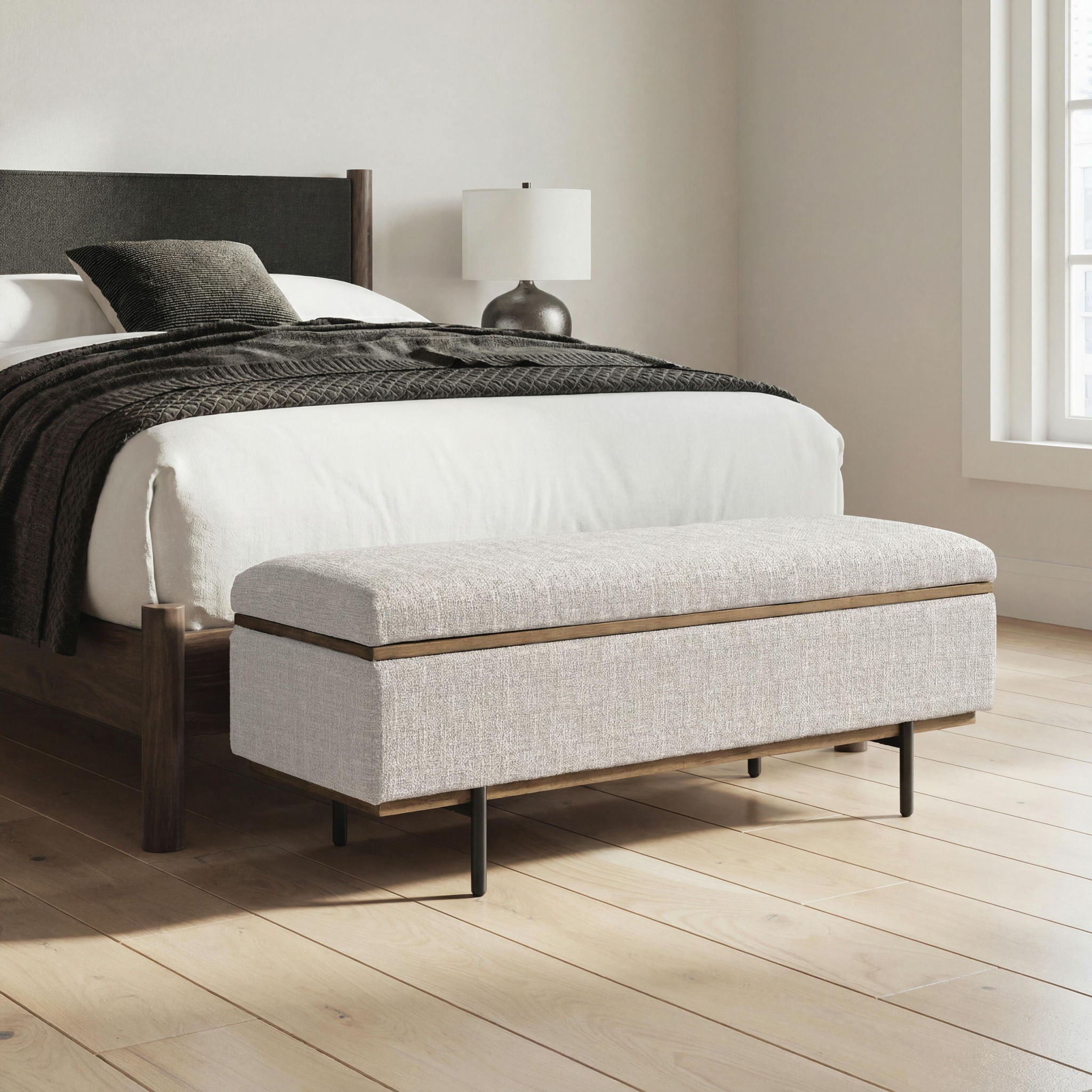 Stone upholstered storage bench with hinged top and dark metal legs